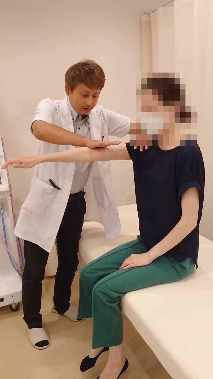 腕の力の入り方を確認する検査風景。患者さんの顔はモザイク処理済み